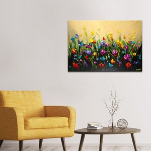 May include: A painting of a field of colorful flowers in shades of purple, blue, yellow, red, and green. The flowers are painted in a thick, textured style, giving the painting a three-dimensional effect.