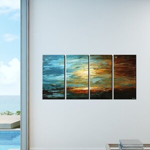 May include: A modern living room with a large window overlooking a pool and ocean. A multi-panel abstract painting depicting a sunset over water hangs on the wall. The painting is in shades of blue, orange, and brown. A coffee table with books and a cup sits in front of the painting.