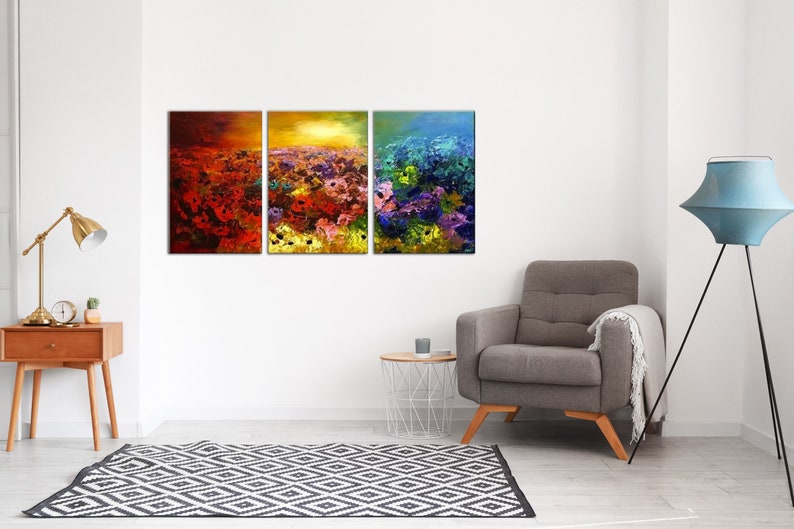 May include: A three-piece abstract painting set featuring a field of colorful flowers with a sunset in the background. The paintings are framed in wood and have a textured, brushstroke effect.