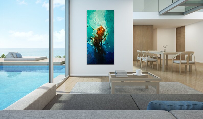 May include: Abstract painting with blue, green, and orange colors. The painting is hanging on a white wall in a modern living room with a pool view.