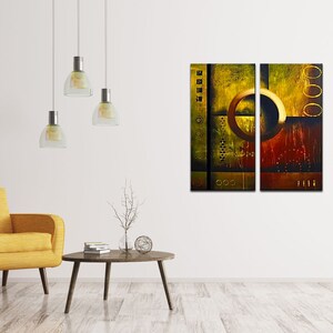 May include: Abstract art print in a modern style with a yellow, brown, and gold color scheme. The print is divided into two panels, each featuring a large circle with a textured background.