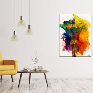 May include: Abstract painting with vibrant colors, including yellow, orange, red, green, blue, and purple, on a white background. The painting is displayed in a living room setting with a yellow armchair and a coffee table.