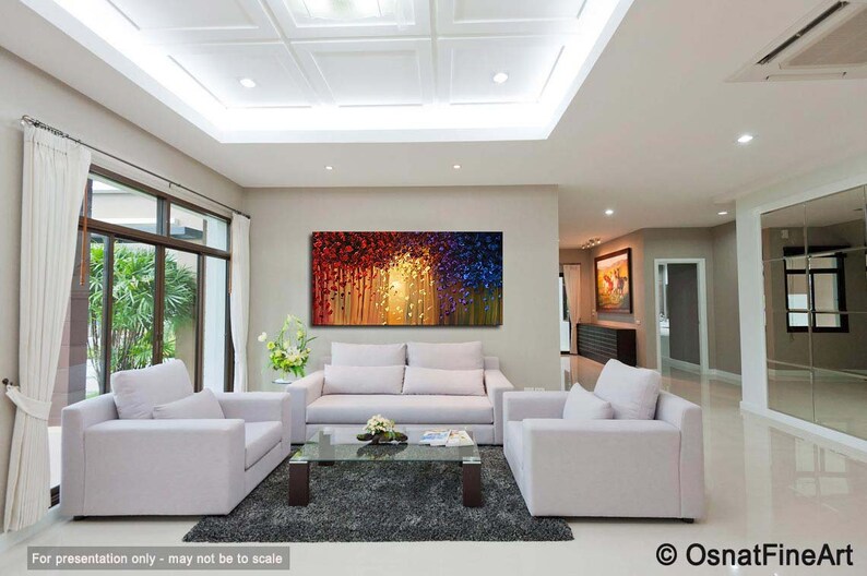 May include: A modern living room interior with white couches and a coffee table. A large abstract painting with red, yellow, and blue colors hangs on the wall.