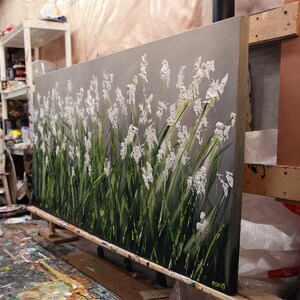 May include: A large abstract painting of white flowers on a gray background. The flowers are painted with thick, textured strokes of paint, giving them a three-dimensional appearance. The painting is on a canvas and is stretched over a wooden frame.