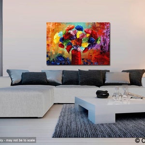May include: An abstract painting of a bouquet of colorful flowers in a red vase. The artwork features a vibrant mix of colors, including red, yellow, blue, and purple. The painting is displayed above a white couch in a modern living room setting.