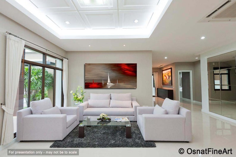 May include: A living room interior with white couches and a coffee table. A large abstract painting of a red sunset with white sailboats hangs on the wall.