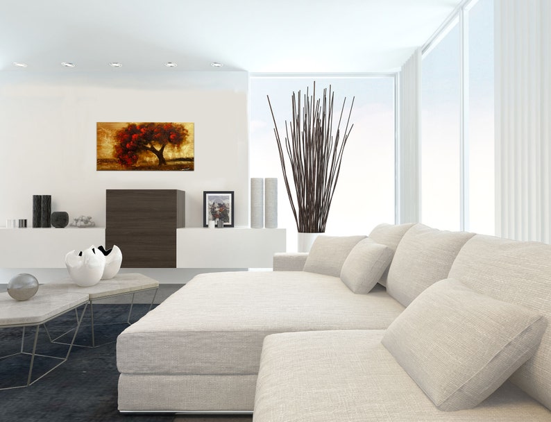 May include: A white sectional sofa with multiple pillows in a modern living room. A painting of a red tree on a gold background hangs on the wall.