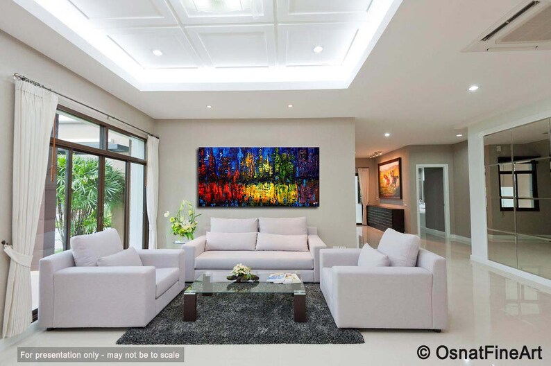 May include: Abstract painting in a modern living room with white couches and a coffee table. The painting features a cityscape with vibrant colors, including red, yellow, blue, and green.