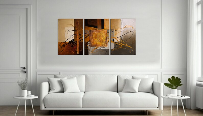May include: Abstract art print in a tri-panel set. The print features a mix of brown, gold, and black colors with abstract shapes and lines.