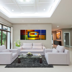 May include: A modern living room with white couches and a coffee table. A large abstract painting with blue, green, yellow, and orange colors hangs on the wall.
