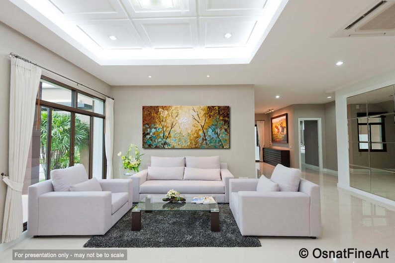 May include: A living room interior with white couches and a coffee table. A large abstract painting with blue, green, and yellow colors hangs on the wall.