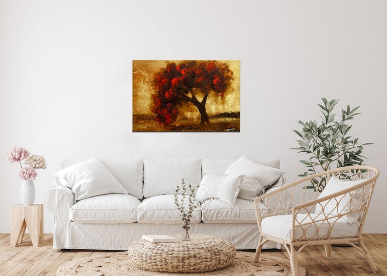 May include: A painting of a lone tree with red leaves against a golden background. The tree is in the center of the canvas and is surrounded by a soft, golden light. The painting has a warm and inviting feel.