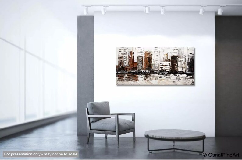 May include: Abstract painting of a city skyline in shades of brown, gray, and white. The painting is displayed on a white wall in a modern interior setting.