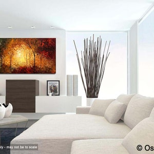 May include: A painting of a forest scene with trees in shades of green, brown, and red. The trees are silhouetted against a bright orange and yellow sky. The painting is hanging on a white wall in a modern living room.