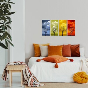 May include: Four framed canvas prints depicting a bare tree in different seasons. The prints are arranged in a row, with the first showing a blue sky with clouds, the second showing a yellow sky with clouds, the third showing a green sky with clouds, and the fourth showing a red sky with clouds.