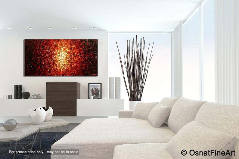 May include: Abstract painting with a red, orange, and yellow color scheme. The painting is displayed on a white wall in a modern living room setting.
