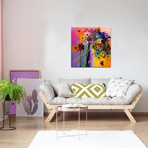 May include: A colorful abstract painting of flowers in a vase. The painting is in a modern style with bold colors and brushstrokes. The painting is hanging on a white wall in a living room setting.