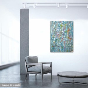 May include: Abstract painting with a textured surface in shades of blue, white, and yellow. The painting is hanging on a white wall in a modern living room setting.