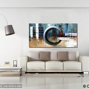 May include: Abstract painting with a large, circular, metallic gray shape in the center. The painting is on a white wall above a white couch with brown throw pillows. The painting has a blue, gray, white, and brown color scheme.