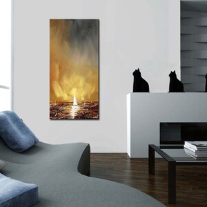 May include: An abstract painting of a seascape with sailboats. The artwork features a warm color palette of gold, brown, and gray, with a focus on the reflection of light on the water. The painting is displayed in a modern living room setting.