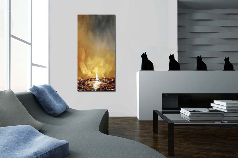 May include: An abstract painting of a seascape with sailboats. The artwork features a warm color palette of gold, brown, and gray, with a focus on the reflection of light on the water. The painting is displayed in a modern living room setting.