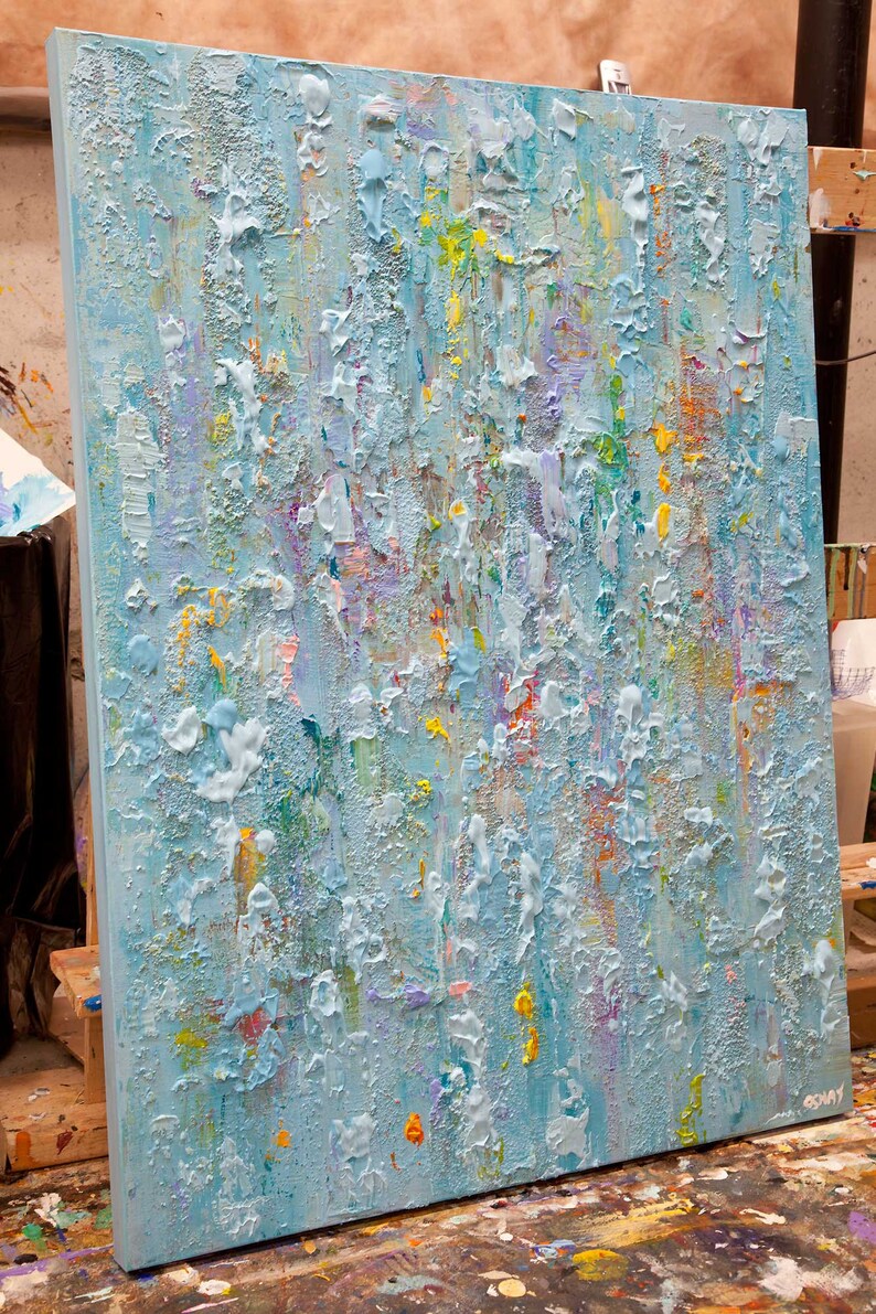 May include: Abstract painting on canvas with a textured surface. The painting is predominantly light blue with accents of yellow, green, pink, and purple.
