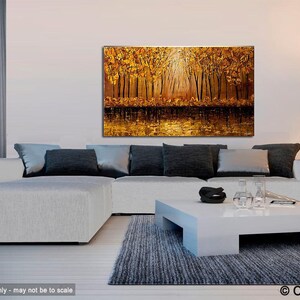 May include: A large abstract painting of a forest scene with golden and brown hues. The painting depicts a group of trees with their branches reaching towards the sky. The light shines through the trees, creating a warm and inviting atmosphere. The painting is displayed on a white wall above a white couch and coffee table.