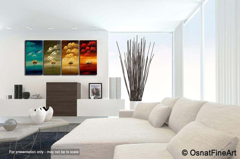 May include: A set of four abstract paintings depicting trees with colorful skies. The paintings are in a modern living room setting with a white couch and a vase of branches.