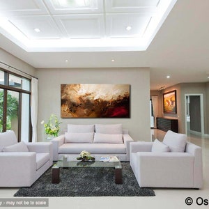 May include: Abstract painting in shades of brown, gold, and red, hanging on a wall in a modern living room with white furniture and a glass coffee table.