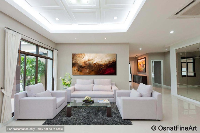 May include: Abstract painting in shades of brown, gold, and red, hanging on a wall in a modern living room with white furniture and a glass coffee table.