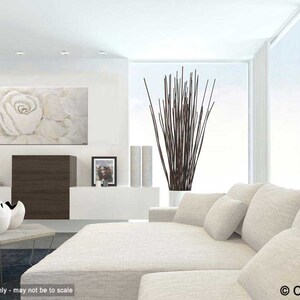 May include: A white, abstract painting of a single rose with a light brown background. The painting is hanging on a white wall in a modern living room with a white sectional sofa and a vase of brown branches.