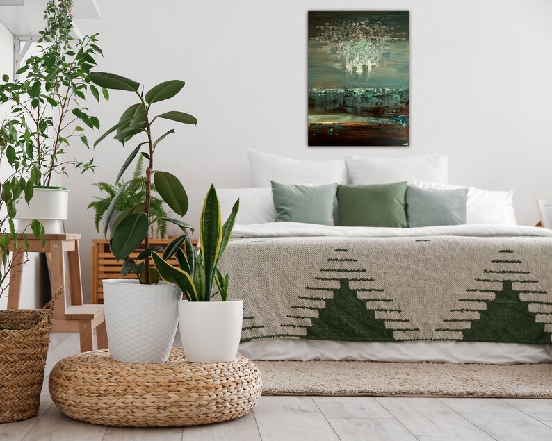 May include: A bedroom with a bed with a green and white patterned blanket, a white headboard, and green pillows. There is a painting above the bed with a white, blue, and brown abstract design. There are three potted plants in the room.