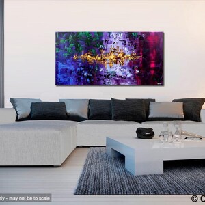 May include: Abstract painting with a mix of purple, green, and gold colors. The painting is displayed on a white wall above a white couch with black pillows.
