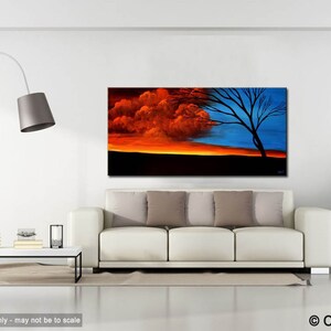 May include: Abstract painting of a tree with a red and blue sky. The tree is silhouetted against the sky, and the colors are vibrant and bold. The painting is framed and hanging on a white wall in a living room setting.