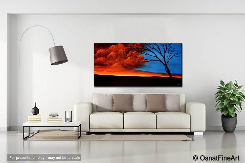 May include: Abstract painting of a tree with a red and blue sky. The tree is silhouetted against the sky, and the colors are vibrant and bold. The painting is framed and hanging on a white wall in a living room setting.