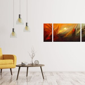 May include: A three-piece abstract art print set with a yellow, orange, and red color scheme. The print features a stylized landscape with a bright white sun in the center.