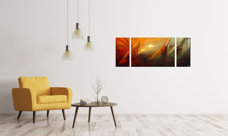 May include: A three-piece abstract art print set with a yellow, orange, and red color scheme. The print features a stylized landscape with a bright white sun in the center.