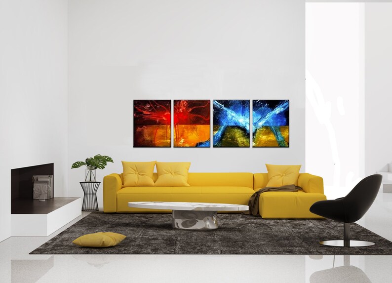 May include: Four abstract paintings in a modern living room. The paintings are in a grid formation and feature red, orange, yellow, blue, and green colors. The paintings are hung on a white wall above a yellow sofa.