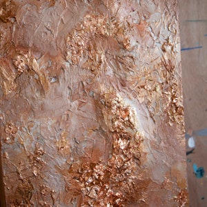 May include: Abstract painting with a textured, layered surface. The painting features shades of brown, gold, and white, creating a metallic and earthy effect.