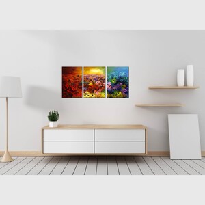 May include: A three-piece abstract art print set featuring a colorful landscape with shades of red, orange, yellow, green, and blue. The prints are framed and displayed on a white wall above a white dresser.