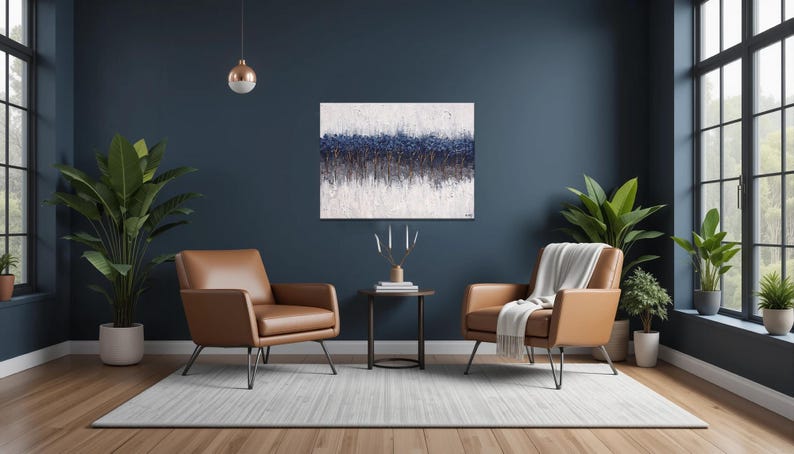 May include: A modern living room with two brown leather armchairs, a small round table, and a large abstract painting. The room features large windows, indoor plants, and a neutral rug. The walls are painted a dark blue.
