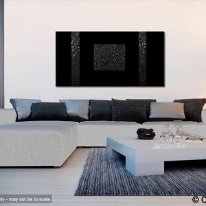 May include: A black and white abstract painting with a textured surface hangs on a white wall above a white sectional sofa with black pillows. A white coffee table sits in front of the sofa with a black rug underneath.