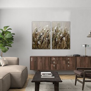 May include: A split canvas wall art featuring a close-up of a field of tall grasses and white flowers in shades of brown, beige, and white.