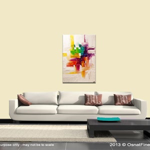 May include: Abstract painting with a white background and colorful geometric shapes in shades of red, orange, yellow, green, blue, purple, and pink. The painting is displayed on a white wall above a white couch with brown pillows.