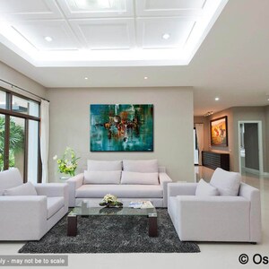 May include: Abstract painting in shades of teal, brown, and white, hanging on a wall in a living room with white couches and a coffee table. The painting is framed and has a modern style.