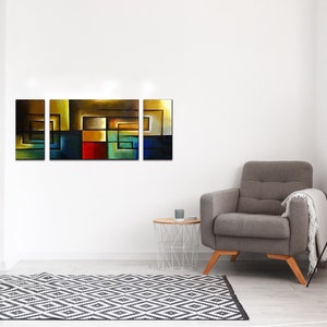 May include: A four-piece abstract art print set featuring geometric shapes in shades of blue, green, yellow, red, and brown. The prints are arranged horizontally on a white wall above a gray armchair.