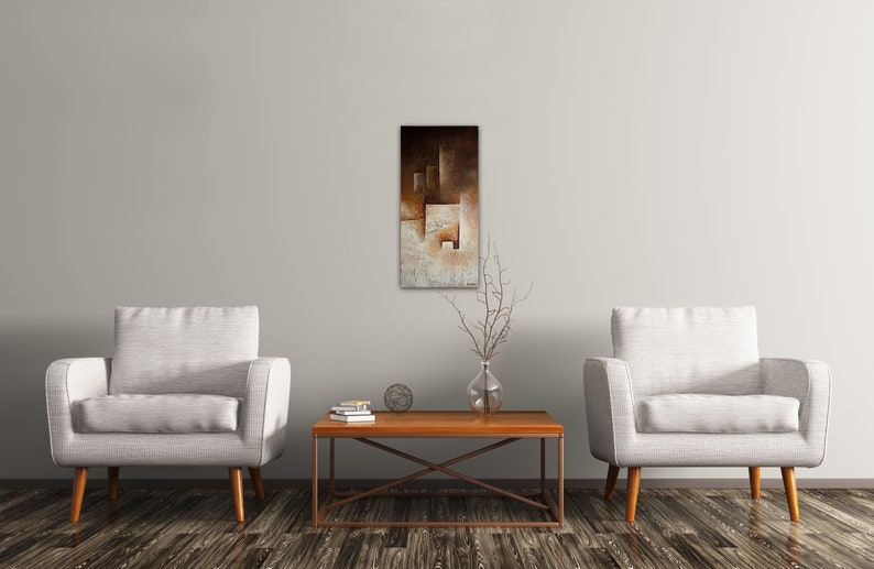 May include: Two white armchairs with wooden legs face each other across a wooden coffee table with a metal frame. A brown and white abstract painting hangs on the wall behind the table.
