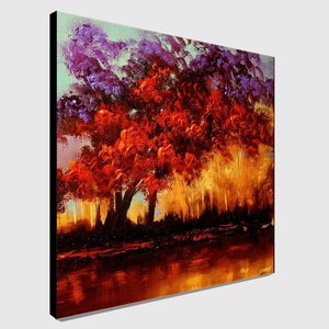 May include: A painting of a landscape with a large red tree in the foreground. The tree is surrounded by smaller trees and a body of water. The sky is a light blue color with purple clouds.