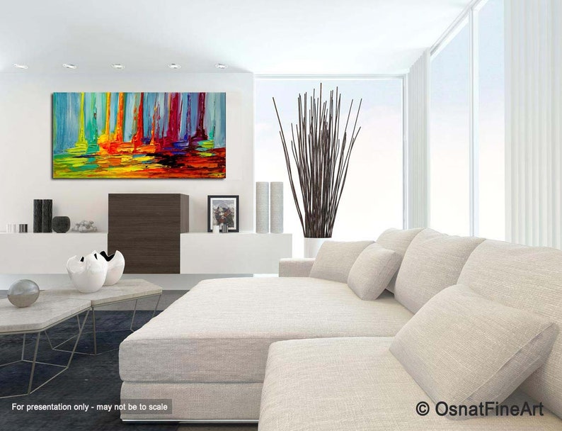 May include: Abstract painting with vertical brushstrokes in shades of blue, green, yellow, orange, and red. The painting is displayed on a white wall in a modern living room setting.