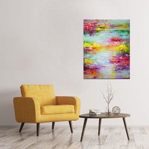 May include: Abstract painting with vibrant colors, including pink, purple, yellow, and green. The painting has a textured, brushstroke effect and depicts a landscape with water and flowers.